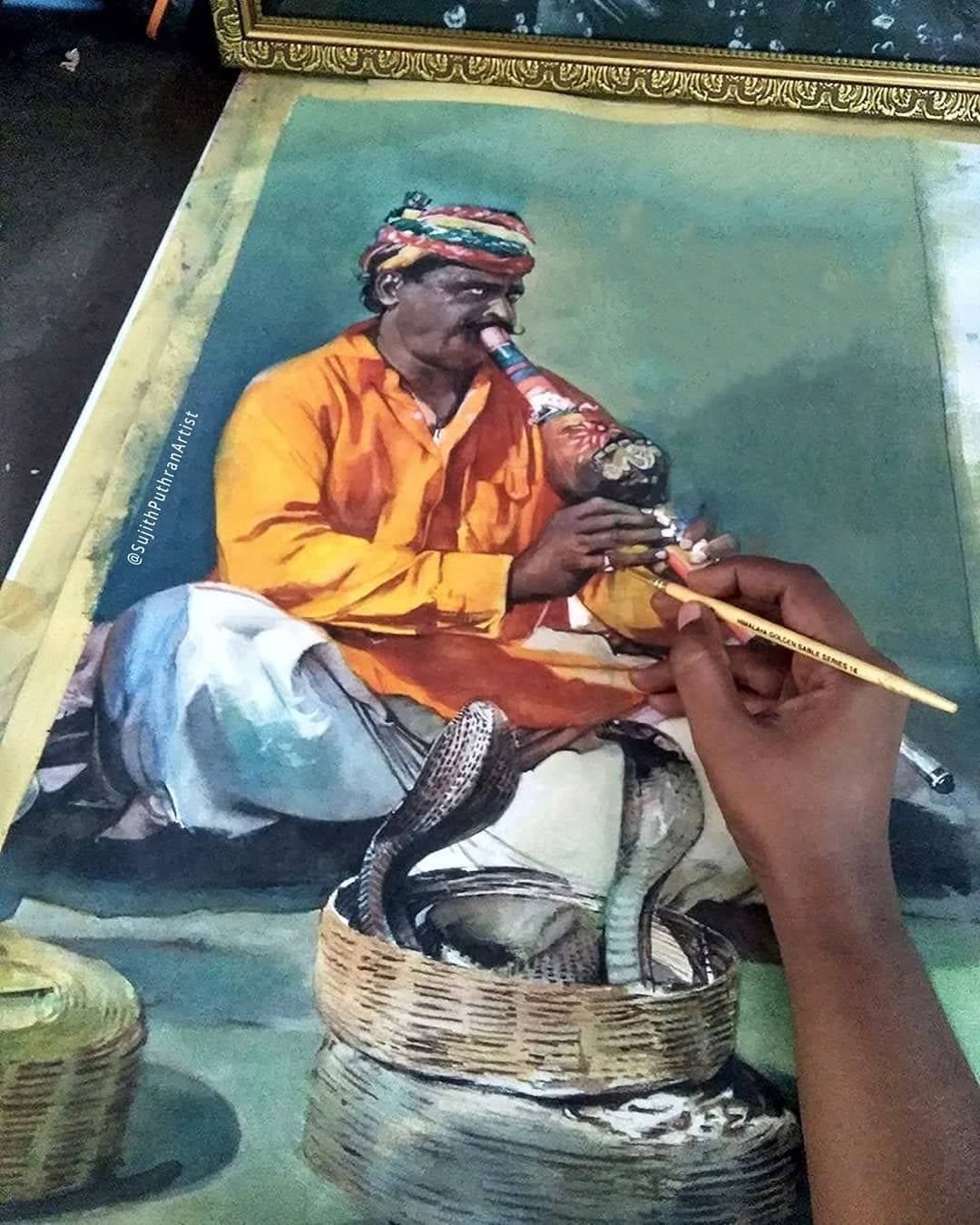 Sujith Puthran's hand at work on a watercolour painting of a snake charmer, brush mid-stroke